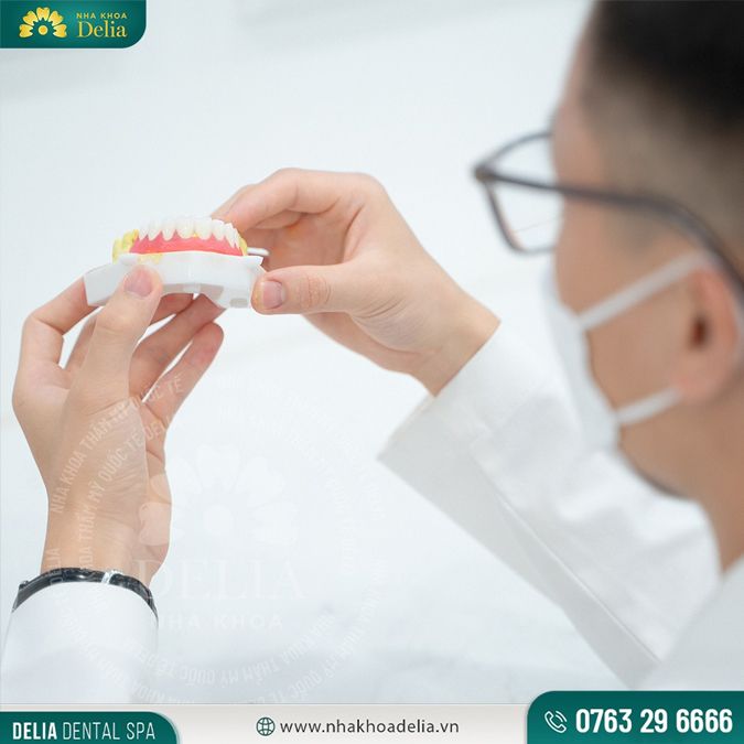 Bác sĩ hoàn thiện răng sứ trên hàm răng giả trước khi đưa lên hàm thật