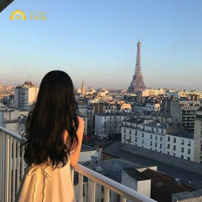 Tựa vào ban công, tay đặt nhẹ lên lan can